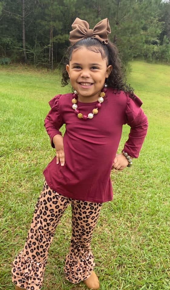 Girl Wearing Brown Bow with a Burgundy shirt and cheetah leggings 